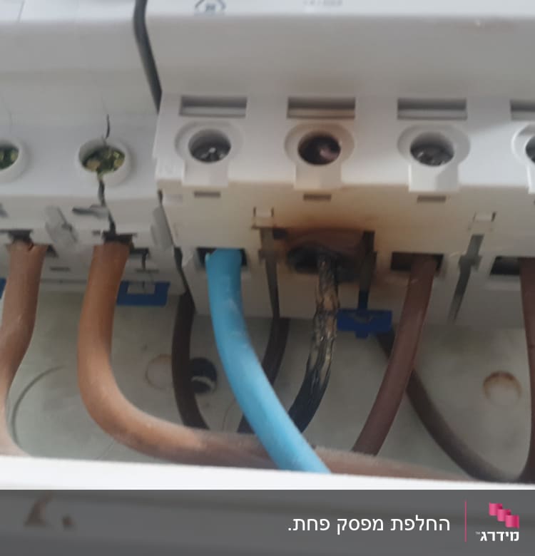 חוטים חשמליים מחוברים למפסק עם סימני שריפה